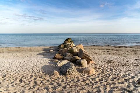 A beach with a large pile of rocks on it Stock Photos