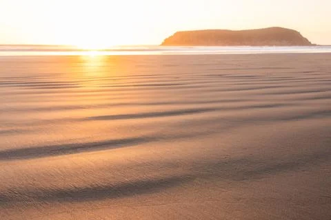 A beach with a large rock in the background Stock Photos