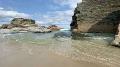 Beach with large rocks where the sea water approaches the shore Stock Footage 160476531
