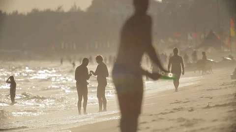 Beach life. People are walking along the beach, playing frisbee, having fun. Stock Footage 45280775