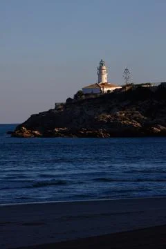 Beach lighthouse with cloudless blue sky and calm blue sea Stock Photos
