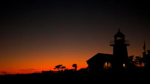 Beach lighthouse at sunset Stock Photos