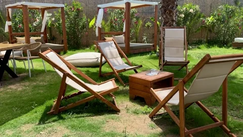 Beach Lounge Chairs and Table on Green Lawn at Beach Bar in Halkidiki Greece Stock Footage 338002132