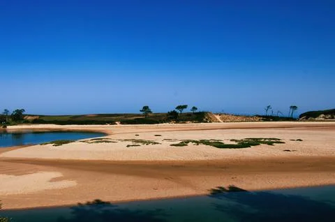 Beach at low tide with sand dune Stock Photos