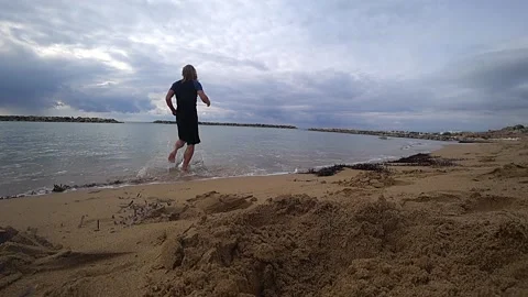 By the beach with a man running into the water Stock Footage 188440389