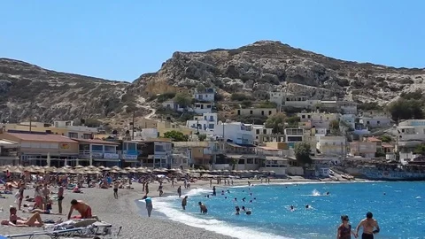 The beach of Matala with the town in the background, Crete, Greece. Stock-Footage 79853614