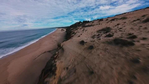 Beach meets sky, wind moves sand and grass Stock Footage 340905490