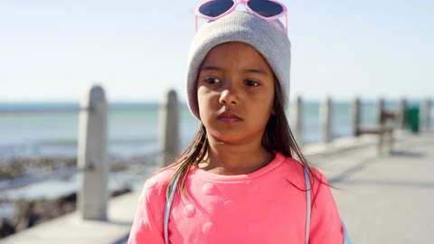 Beach, miserable and thinking with girl kid outdoor for holiday, travel or 動画素材 331348414