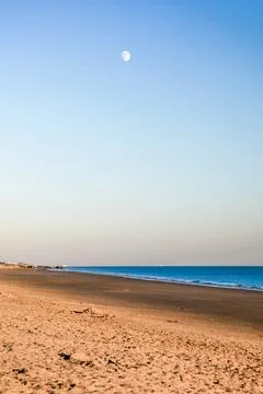 A beach with a moon in the sky Stock Photos