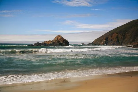 A beach with a mountain in the background Stock Photos