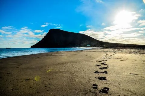 A beach with a mountain in the background Stock Photos