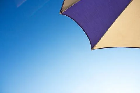 Beach multi-colored umbrella on background blue sky Stock Photos