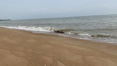 A beach is a narrow, gently sloping strip of land that lies along the edge Stock Photos