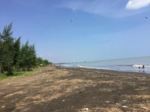 A beach in the north of Java with dark brown sand. Stock Photos