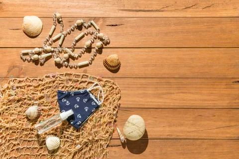 Beach objects, face mask and hydro alcoholic gel on wooden boards. Stock Photos