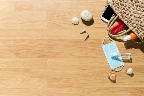Beach objects, face mask and hydro alcoholic gel on parquet flooring. Stock Photos