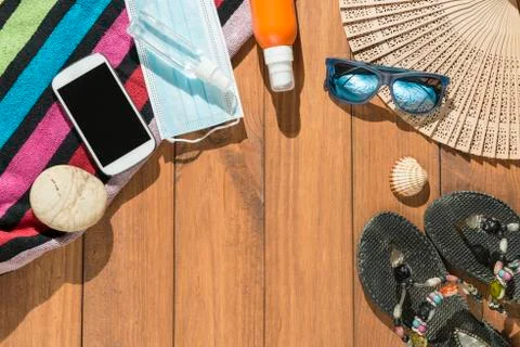 Beach objects, face mask and hydro alcoholic gel on wooden boards. Stock Photos