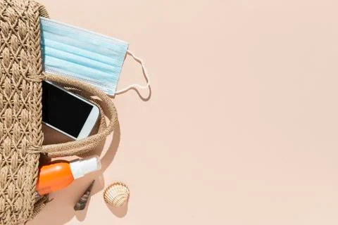 Beach objects, face mask and hydro alcoholic gel on pink background. Stock Photos