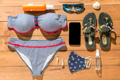 Beach objects, face mask and hydro alcoholic gel on wooden boards. Stock Photos