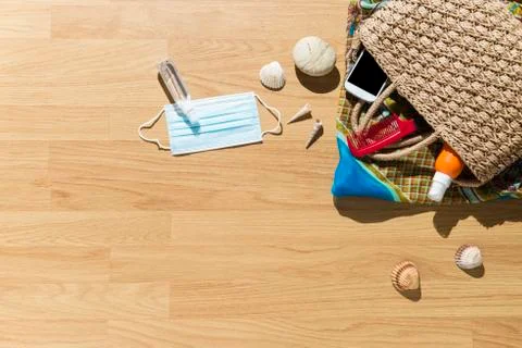 Beach objects, face mask and hydro alcoholic gel on parquet flooring. Stock Photos