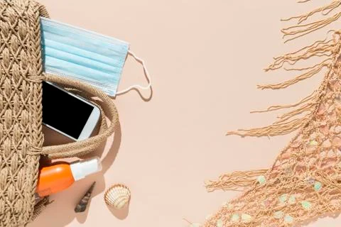 Beach objects, face mask and hydro alcoholic gel on pink background. Stock Photos