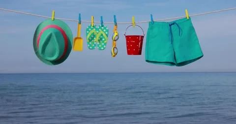 Beach objects hanging against blue sky and sea. Slow motion 스톡 동영상 234816672