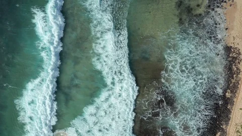 Beach overhead drone shot. Shorebreak waves rolling to sandy rocky beach, Hawaii Video stock 128302724