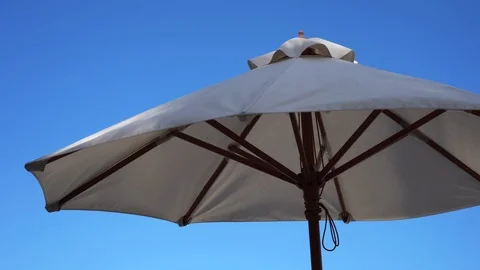 Beach Parasol close up in shade as warm tropical breeze blows Stock Footage 114178172