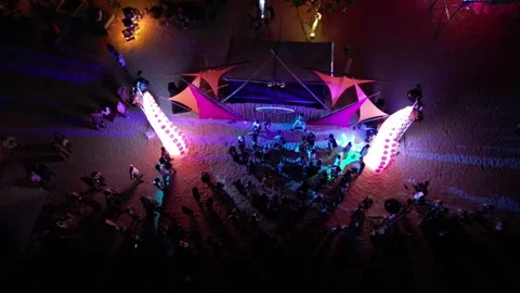 Beach party with dancing and illuminations in the evening. Top view. Drone video Video stock 297544498