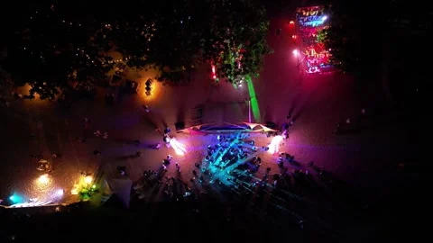 Beach party with dancing and illuminations in the evening. Top view. Drone video Stock-Footage 297544505