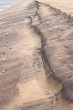 Beach pattern by waves on sand Stock Photos