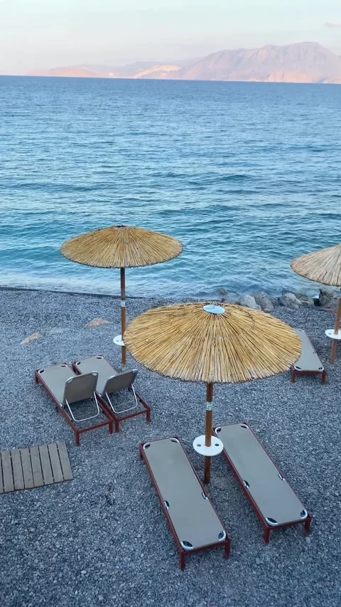 Beach pebbles. Beach umbrellas. Sun loungers. Vertical video Stock Footage 287492603