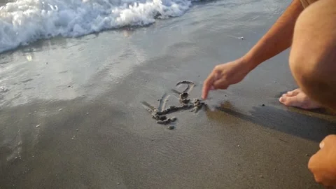 The beach in Pefki, Greece, a hand trying to write something on the fine sand Stock Footage 265173824