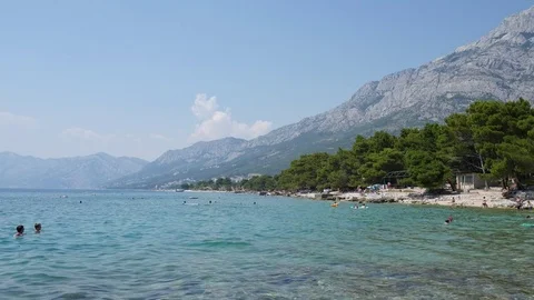 Beach with people, trees and mountain Stock Footage 78908527