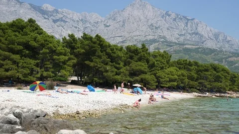 Beach with people, trees and mountain Stock Footage 78909583