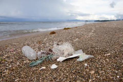 Beach pollution. Plastic bottles and other trash on sea beach. Ocean pollutio Stock Photos