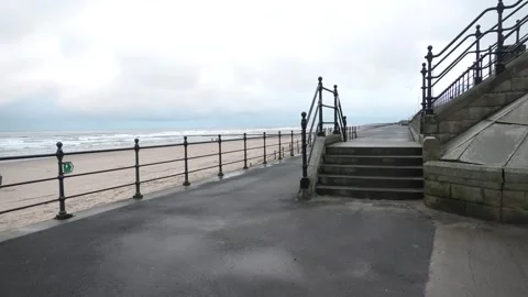 Beach prom railings steps damp grey day Stock Footage 260503090