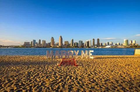 Beach proposal setup with 'Marry Me' sign and skyline of San Diego, California Stock-Fotos