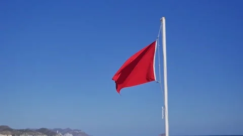 Beach red warning flag fluttering in the wind Stockbeeldmateriaal 284000784