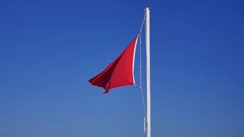 Beach red warning flag fluttering in the wind Видео 284012562
