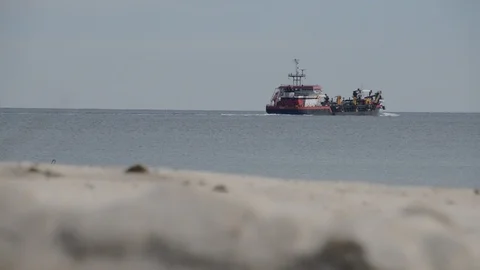 Beach Replenishment Hopper Dredger Ship with Sand Dune in Foreground Stock Footage 102747316