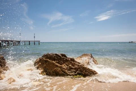 Beach with rocks and blue sky. Summer vacation background Stock Photos