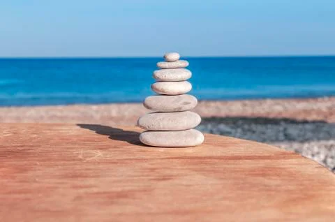 Beach round pebble stone set balance arrangement like zen symbol on wooden table Stock Photos