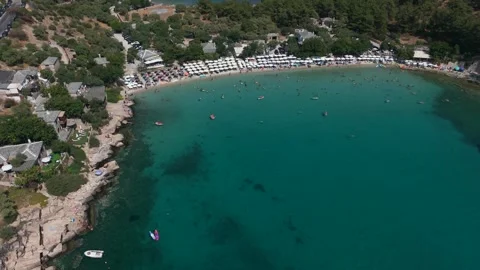 Beach with rows of umbrellas and bathers in a bay at Aliki, Thassos Stock-Footage 347176441