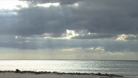 Beach with sand and rocks on a calm day Stock Footage 86365541