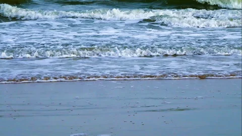 Beach sand with ocean waves gently rolling toward shore Stock Footage 87488750