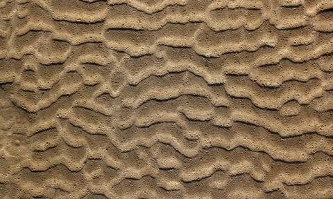 Beach sand waves pattern texture brown wet Stock Photos