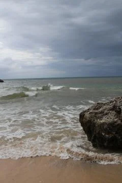 Beach with sand, waves, sky and rock 스톡 사진