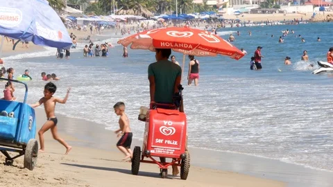 Beach scene: Close up view of an Ice cream vendor in a crowded beach. Stock-Footage 121628853