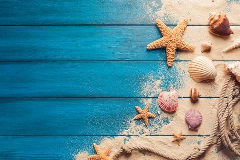 Beach scene concept with sea shells and starfish on a blue wooden background Foto stock